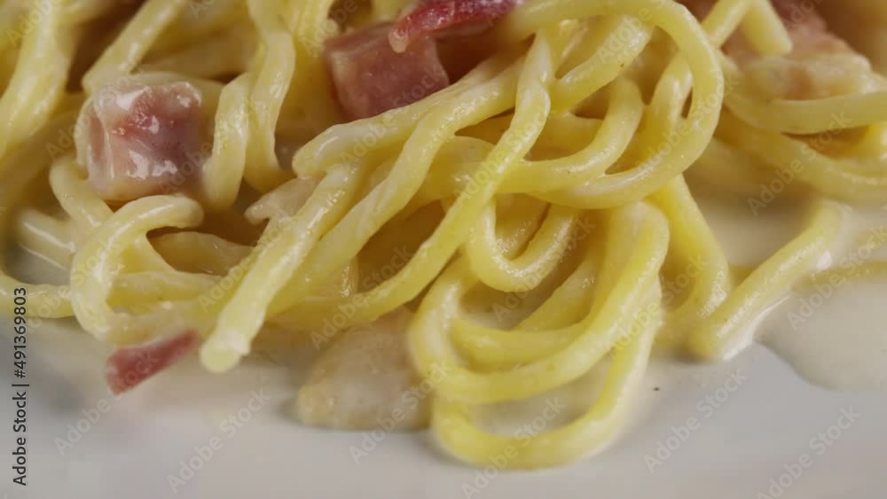 close up carbonara spaghetti with cream on a white plate, rotation shot close up carbonara spaghetti with cream on a white plate, rotation shot