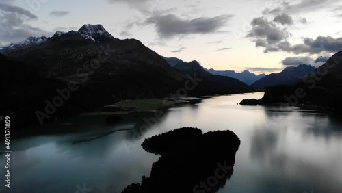 Aerial flyover at sunset over Lake Sils in Engadin, Switzerland with views of the famous Sils Maria peninsula and peaks of Bregaglia photo