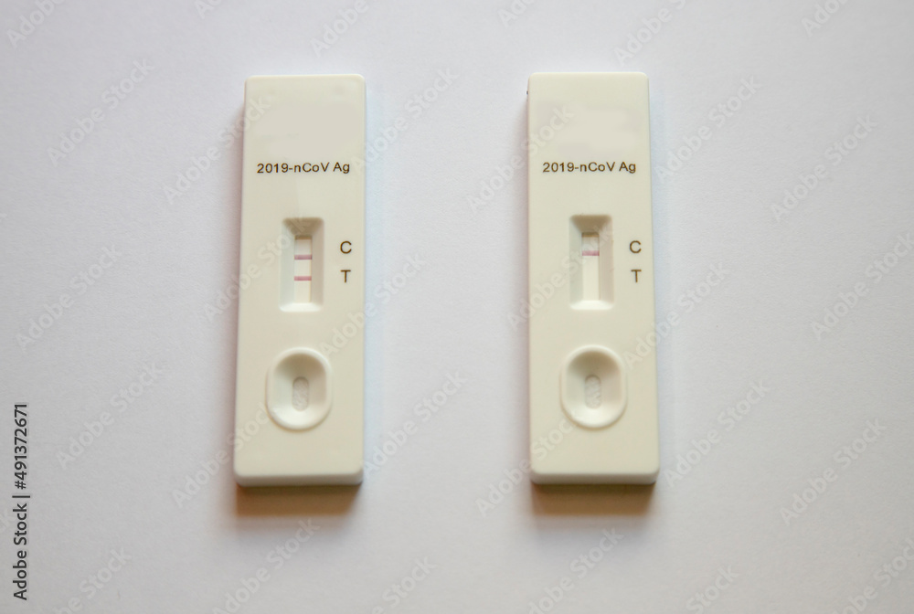 Rapid antigen test (RAT) with COVID-19 Ag inscription.2 stripes showing a POSITIVE result. 1 red stripe showing a NEGATIVE result . Rapid antigen test (RAT) with COVID-19 Ag inscription.2 stripes showing a POSITIVE result. 1 red stripe showing a NEGATIVE result .