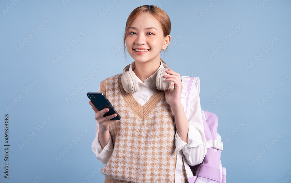 Young Asian high school girl on blue background Young Asian high school girl on blue background