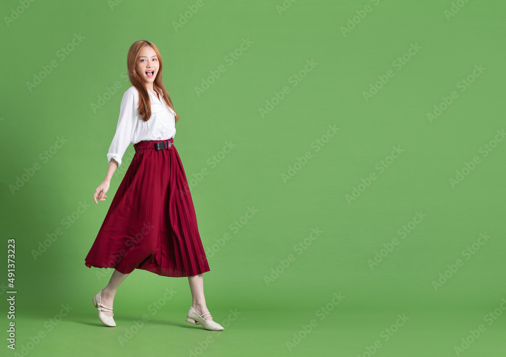 Beautiful young Asian woman dancing and posing on green background Beautiful young Asian woman dancing and posing on green background