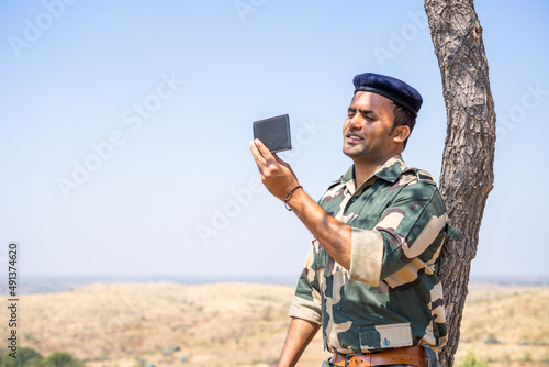 Photography Soldier remebers his family by seeing photo from wallet during service - concept of family affection, bonding and happiness
