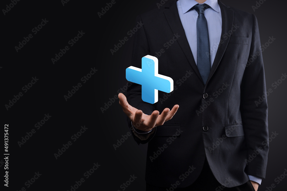 Businessman hold 3D plus icon, man hold in hand offer positive thing such as profit, benefits, development, CSR represented by plus sign.The hand shows the plus sign Businessman hold 3D plus icon, man hold in hand offer positive thing such as profit, benefits, development, CSR represented by plus sign.The hand shows the plus sign
