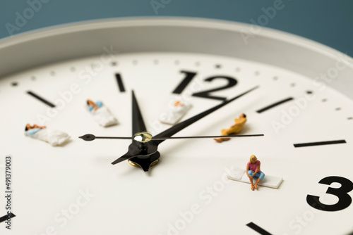 miniature people sleeping on the clock