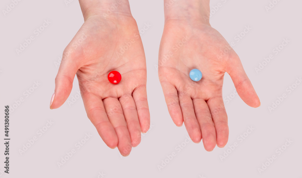 Сhoice between red and blue pills. Woman hands holding tablets. Matrix film. Reality and fantasy concept. High quality photo Сhoice between red and blue pills. Woman hands holding tablets. Matrix film. Reality and fantasy concept. High quality photo