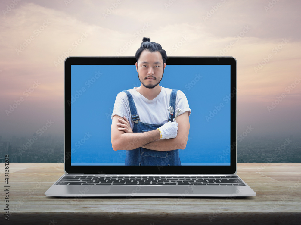 Asian mechanic car engine in uniform with tools and modern laptop computer on wooden table over office city tower and skyscraper at sunset sky, vintage style, Business repair car service online concep Asian mechanic car engine in uniform with tools and modern laptop computer on wooden table over office city tower and skyscraper at sunset sky, vintage style, Business repair car service online concep
