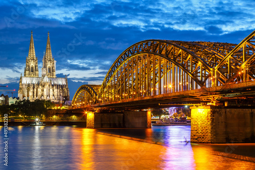 Cologne Cathedral city skyline and Hohenzollern bridge with Rhine river in Germany at twilight