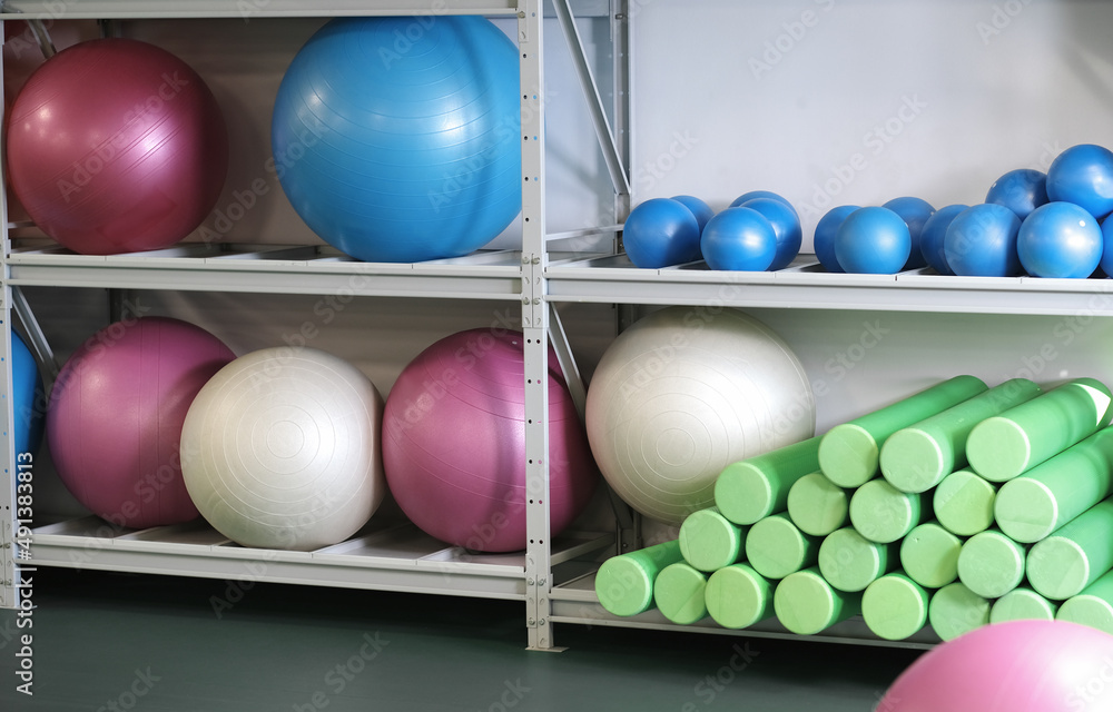 fitness club equipment on a stand. fitballs, yoga foam rollers, healthy lifestyle