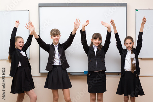 Group portrait of happy schoolchildren near the blackboard