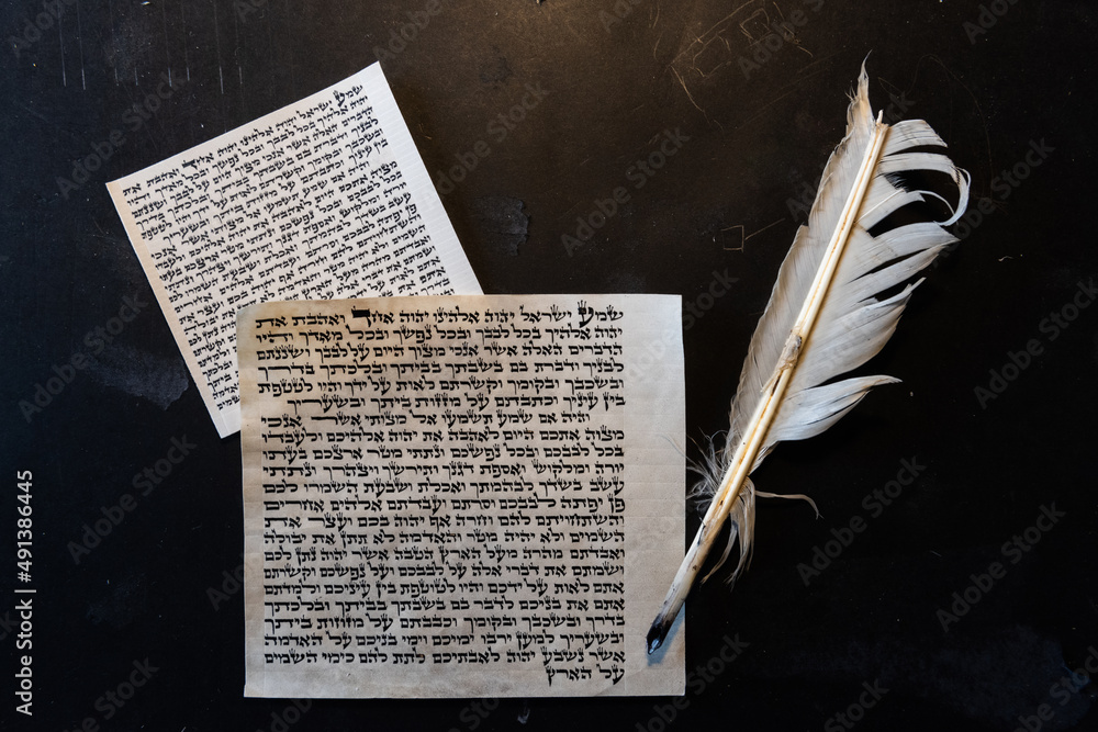 Φωτογραφία Mezuzah parchment made from animal skin with the full text of the Shema Yisrael prayer and the feather quills used to write the Hebrew calligraphy andt text taken from the Bible