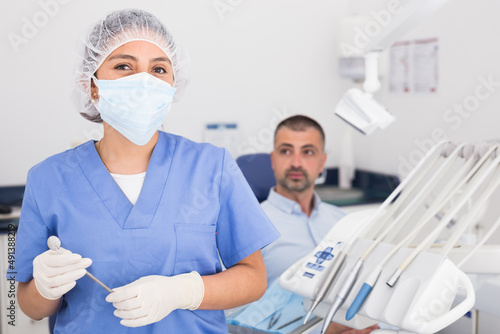 Portrait of professional dentist woman in protective face mask at her workplace in dental clinic office