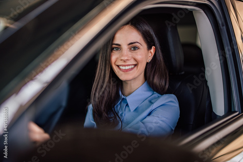 Portrait of brunette adult woman, sitting behind a steering whee photo
