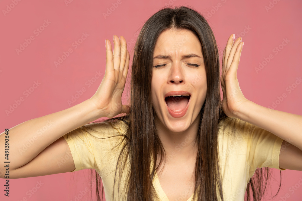 Closeup portrait stressed frustrated woman screaming having temper tantrum isolated on pink background. Negative human emotion facial expression reaction attitude Closeup portrait stressed frustrated woman screaming having temper tantrum isolated on pink background. Negative human emotion facial expression reaction attitude