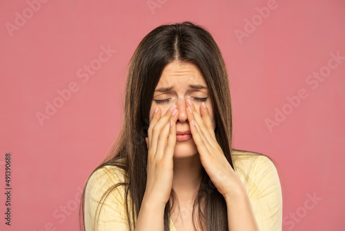 Sinus pain, sinus pressure, sinusitis. Sad woman holding her nose because sinus pain photo