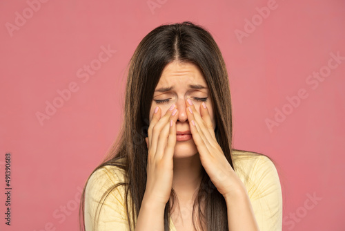 Sinus pain, sinus pressure, sinusitis. Sad woman holding her nose because sinus pain