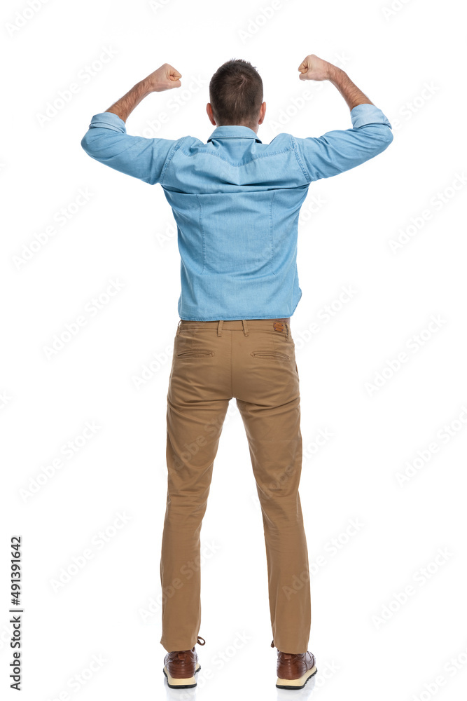 excited young guy holding fists in the air and celebrating victory excited young guy holding fists in the air and celebrating victory