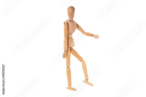 wooden man stands with one arm and leg raised isolated on white background