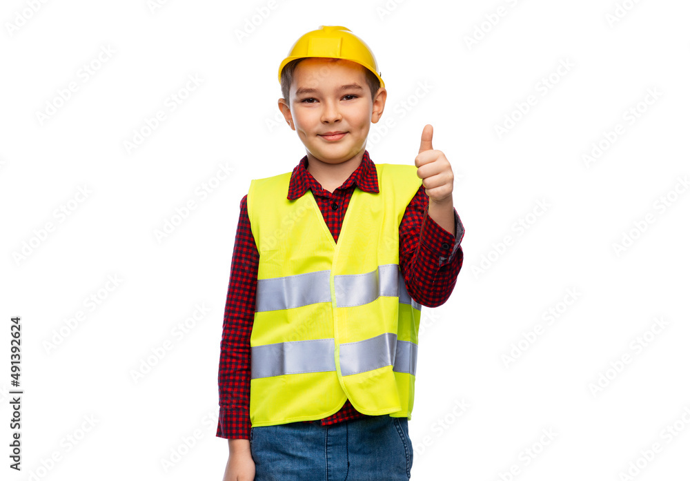 building, construction and profession concept - little boy in protective helmet and safety vest showing thumbs up over white background