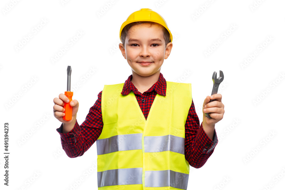 building, construction and profession concept - little boy in protective helmet and safety vest holding screwdriver and wrench over white background building, construction and profession concept - little boy in protective helmet and safety vest holding screwdriver and wrench over white background