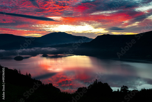 Dawn of time epic sunrise across Derwentwater from Catbells towards Keswick, Skiddaw and Blencathra with the skies on fire in the English Lake District.