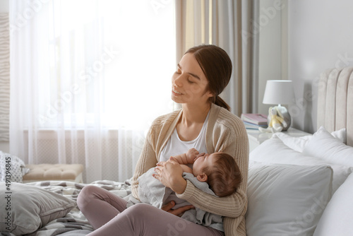 Fotografía Young woman with her little baby on bed at home