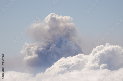 Sea of clouds in the foreground and smoke plume from the volcanic eruption of Cumbre Vieja in the background. La Palma. Canary Islands. Spain.