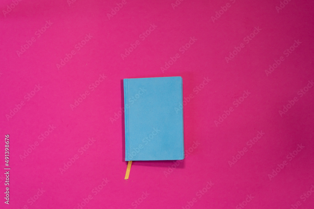 Blue blank notebook for your inscription on a pink summer background. Blue blank notebook for your inscription on a pink summer background.