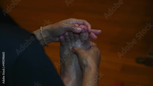 Left hand holding the foot from moving while the right hand works with pressure relaxing ones foot, Foot and Thai Massage or Nuat Phaen Thai, Thailand. photo