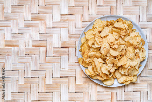 Several sweet crunchy, apple chips on a vine mat, close-up, top view. photo