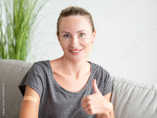 Wallpaper Mural Like gesture. Female patient. Vaccination procedure. Pretty smiling woman showing adhesive plaster on shoulder and thumb up sitting light room interior. Torontodigital.ca