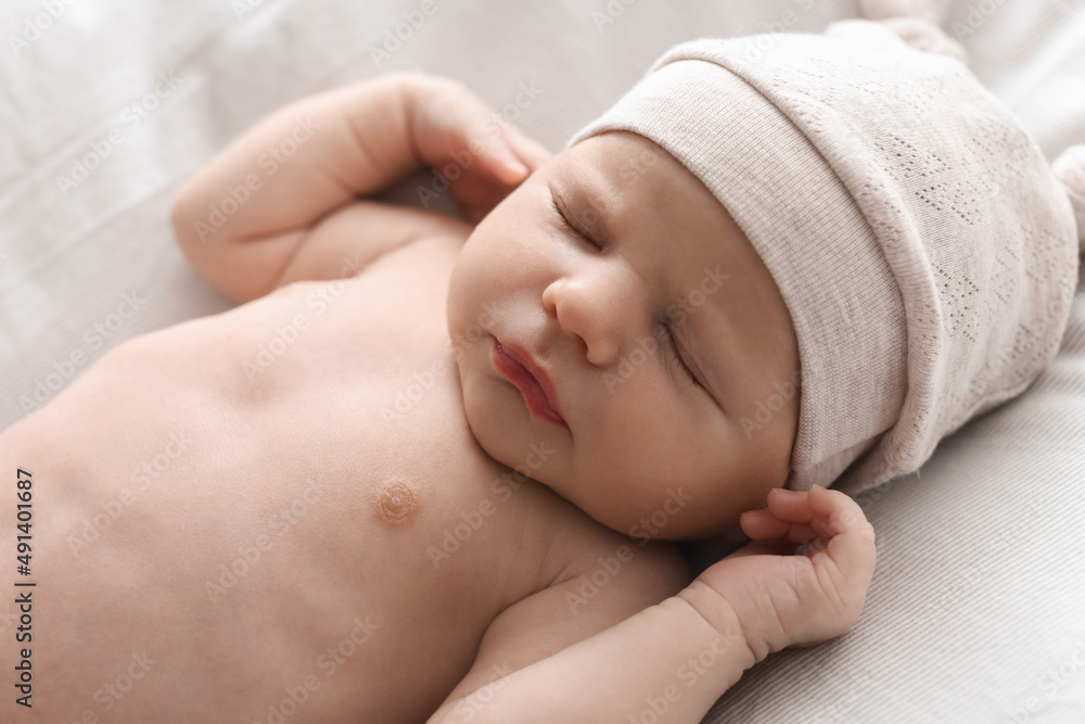 Adorable little baby with hat sleeping on bed, closeup Adorable little baby with hat sleeping on bed, closeup
