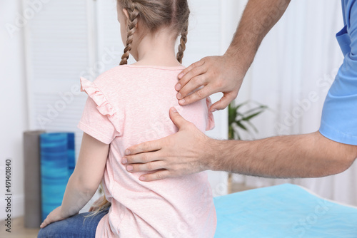 фотографія Orthopedist examining child's back in clinic, closeup