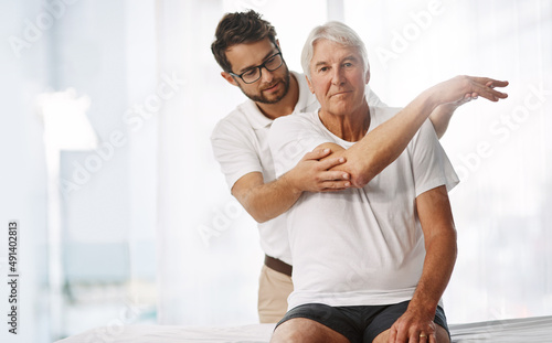 Checking his range of motion. Cropped shot of a young male physiotherapist working with a senior male patient.