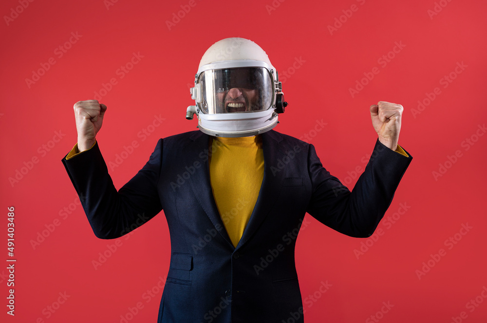 Businessman with astronaut helmet celebrating elated fists Businessman with astronaut helmet celebrating elated fists
