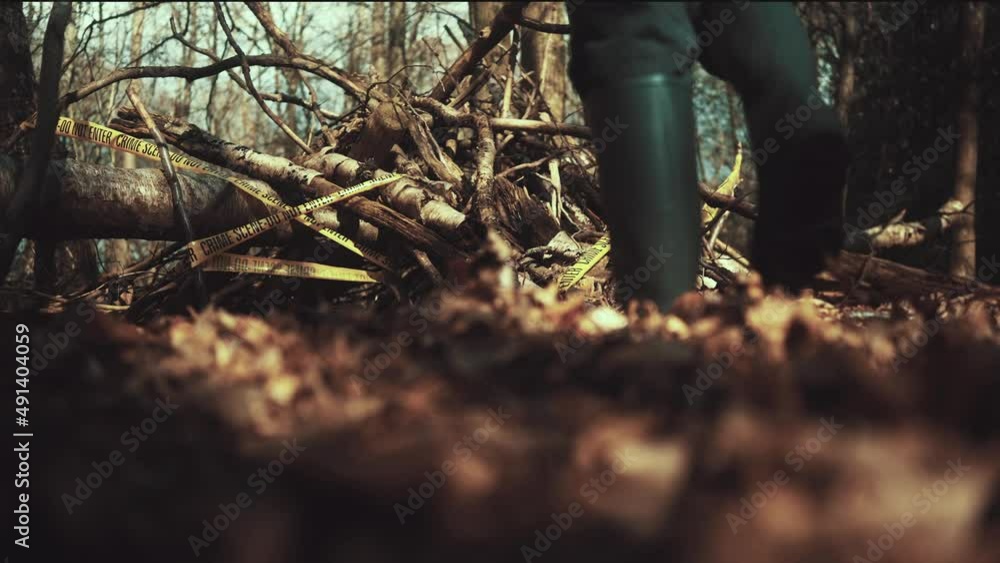 Man walks into a crime scene in the woods. Taped and cornered off area with Crime Scene Tape all around the crime site. Killer on the lose Man walks into a crime scene in the woods. Taped and cornered off area with Crime Scene Tape all around the crime site. Killer on the lose