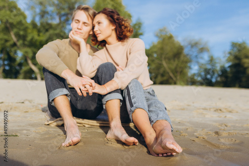 Male and female legs on the beach. Focus on the legs. People are out of focus.