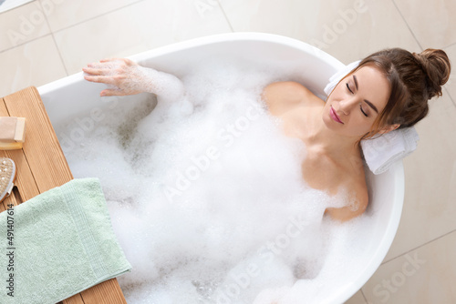 Obraz na plátně Beautiful woman enjoying bubble bath at home, above view