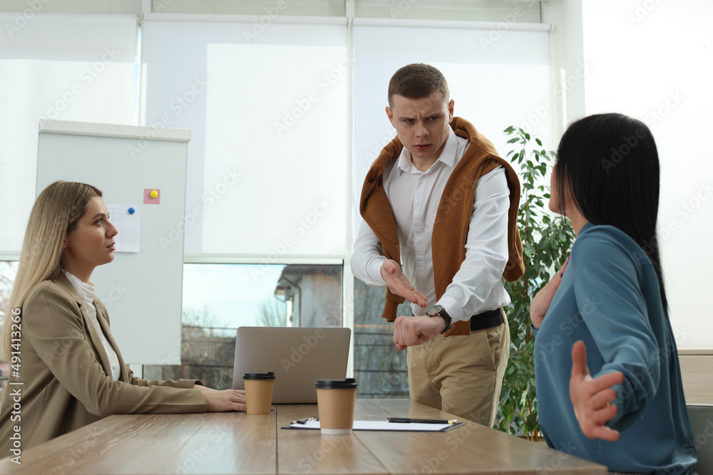 Businessman scolding employee for being late on meeting in office Businessman scolding employee for being late on meeting in office