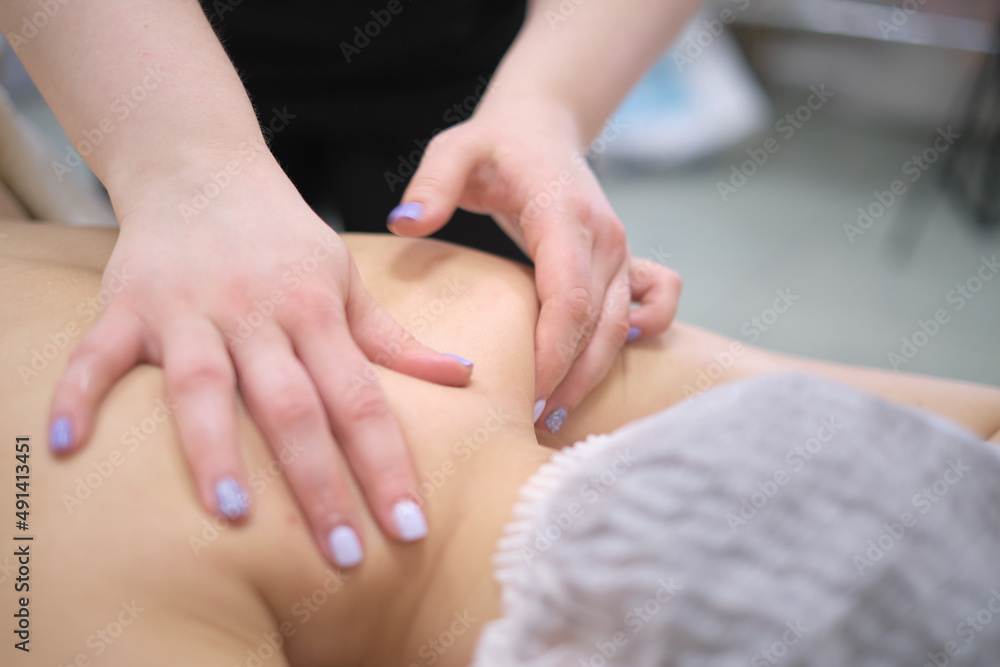Fototapeta premium Closeup masseur hands relaxing or revitalizing massage procedure at spa beauty salon pleasant woman lying on couch enjoying skin and body care