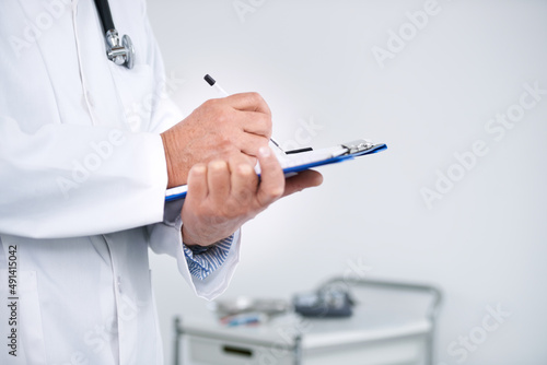 Keeping track of your health. Cropped shot of a doctor standing in his office and holding a clipboard.