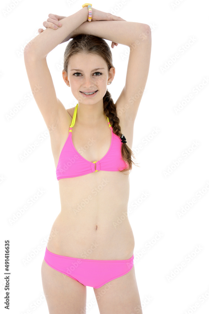 Cheerful teen girl posing in pink bikini in studio isolated on white Stock  Photo