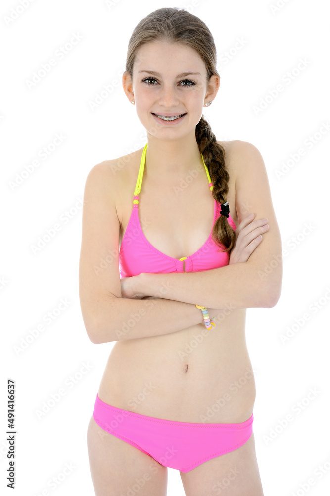 Beautiful slim teenager girl posing in pink bikini in studio isolated on  white Stock Photo