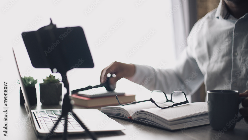 young man making video zoom call in his home office drinking coffee young man making video zoom call in his home office drinking coffee