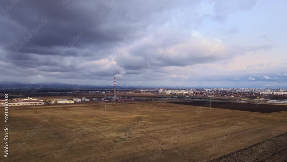 Thermal power plant in operation generating heat. White smoke from the chimney to the atmosphere. Shooting from the air and distance. Thermal power plant in operation generating heat. White smoke from the chimney to the atmosphere. Shooting from the air and distance.