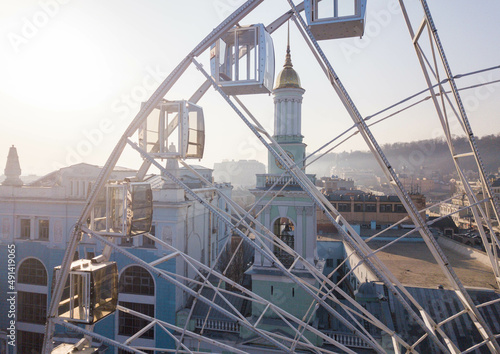Top view of the ferris wheel at Kontraktova square and historic district Podil in Kyiv, Ukraine. Touristic area. Aerial view of the complex of buildings of the former Greek monastery of St. Catherine.