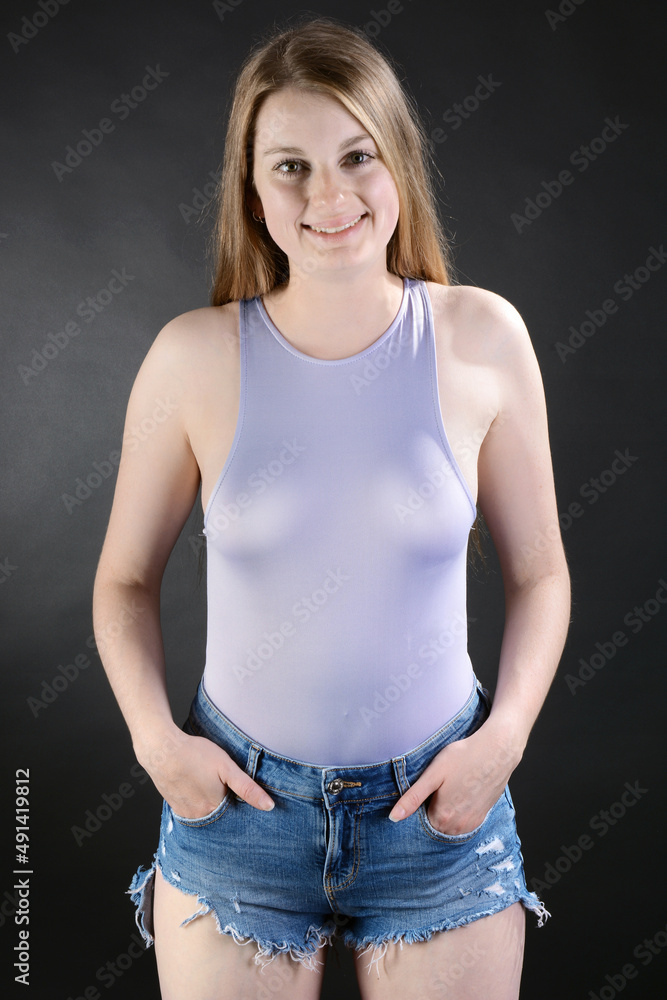 Cheerful woman posing with hot pants and tight top in studio Cheerful woman posing with hot pants and tight top in studio