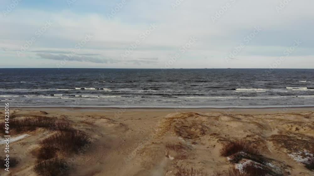 Relaxing aerial view of beautiful sandy seaside with shrubs and land covered in snow on a calm winter day. Latvia, Jurmala Relaxing aerial view of beautiful sandy seaside with shrubs and land covered in snow on a calm winter day. Latvia, Jurmala