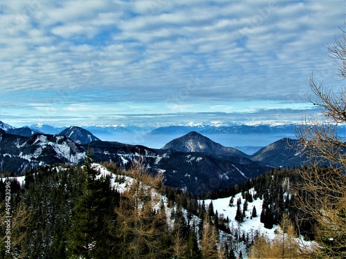 Scenic view of the forest covered hills in the Karavanke mountains in front and fog covered Carinthia region of Austria