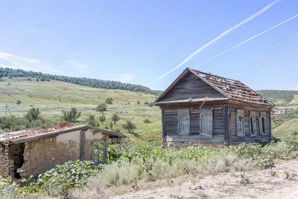 Abandoned log house and dilapidated outbuildings in an abandoned village. Central Russia.