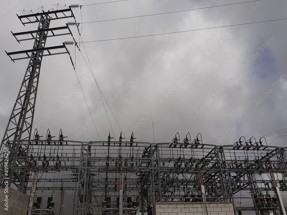 View Of An Electrical Substation With Many Tall Poles And Wiring Lines. Electric Consumption. Industry View Of An Electrical Substation With Many Tall Poles And Wiring Lines. Electric Consumption. Industry